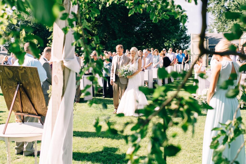 Bride and her dad walking down the aisle during the wedding ceremony at Legacy Hill Farm.