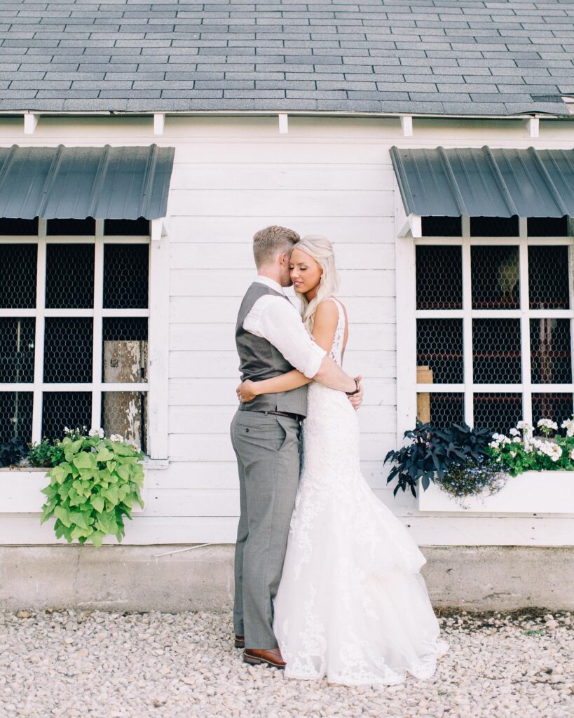 Groom and bride share a quiet, candid hug in a romantic moment, captured at Legacy Hill Farm by Toly Dzyuba Photography.
