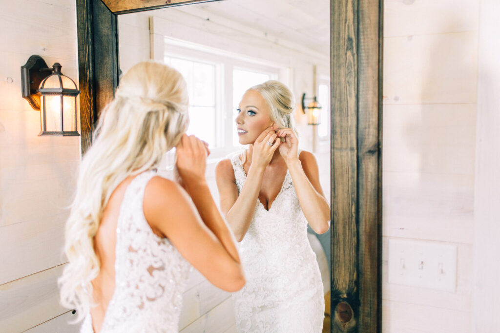 Bride in the mirror putting on her earings at Legacy Hill Farm.