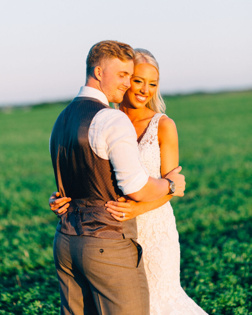 Bride and groom's faces touching, eyes closed, sharing a tender moment on the farm field at Legacy Hill Farm.