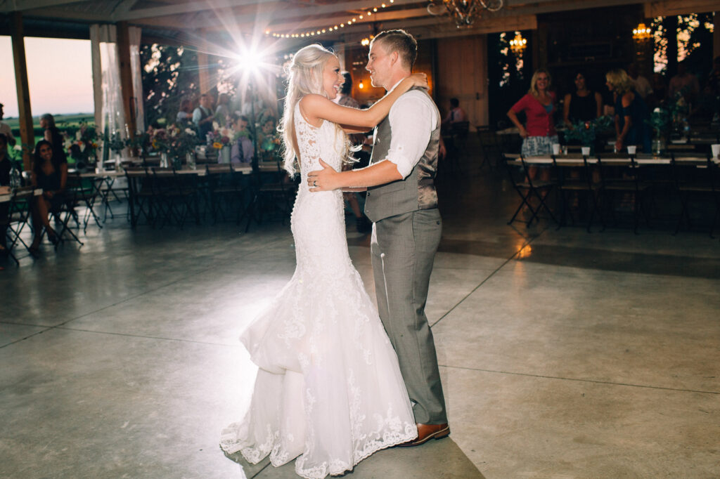 Bride and groom dancing their first dance, looking at each other with joy at dawn at Legacy Hill Farm.