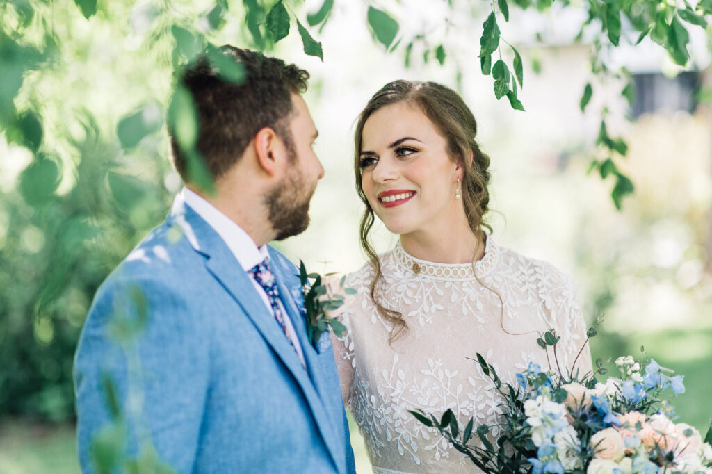 The bride looking in his eyes with a smile at their summer backyard wedding in Minneapolis.