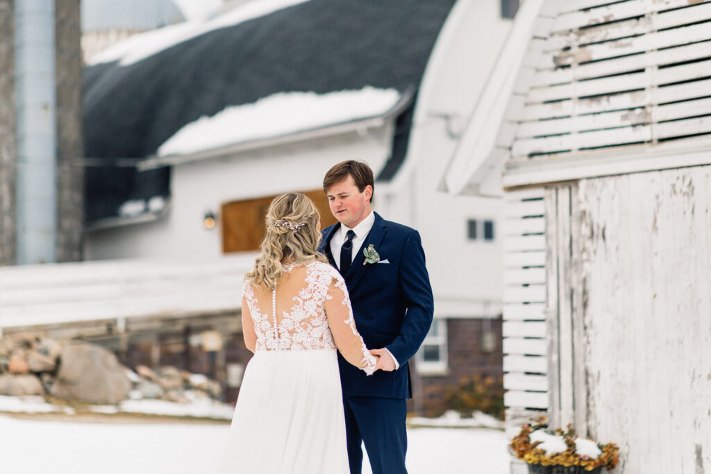 Groom sees her with a big smile during their first look at The Cottage Farmhouse.