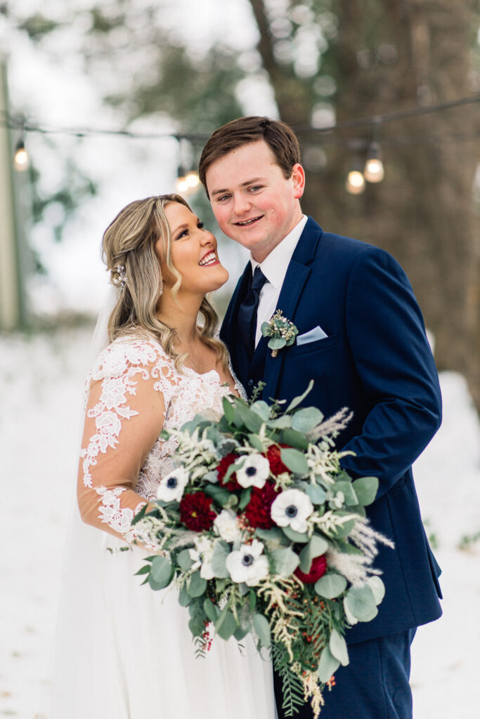 Bride looking at the groom as he smiles at the camera at The Cottage Farmhouse winter wedding.