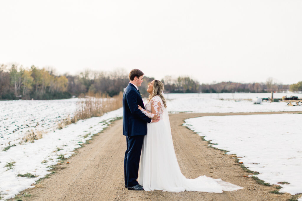 Bride and groom stand facing each other as they look at each other with great joy during sunset at The Cottage Farmhouse.