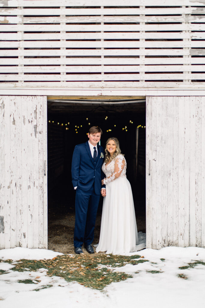 Bride and groom smiling holding hands at The Cottage Farmhouse winter wedding.