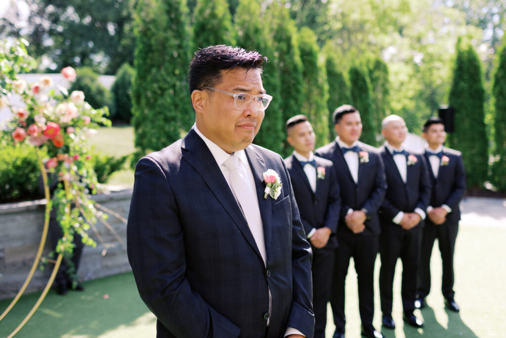 Groom looking at his bride walking down the aisle with emotions at The Hutton House wedding, captured by Minnesota wedding photographer Toly Dzyuba Photography. 