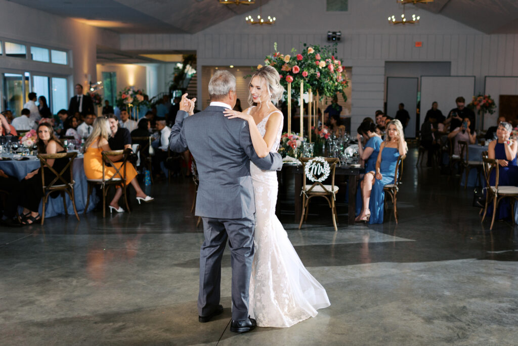 Bride and a father dancing beneath chandeliers at The Hutton House wedding venue in Minneapolis, captured by Minnesota wedding photographer Toly Dzyuba Photography