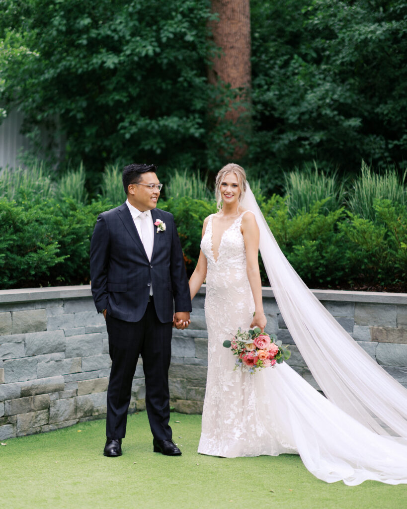 Groom and bride standing together holding hands at The Hutton House wedding venue in Minnesota, photographed by Minnesota wedding photographer Toly Dzyuba.