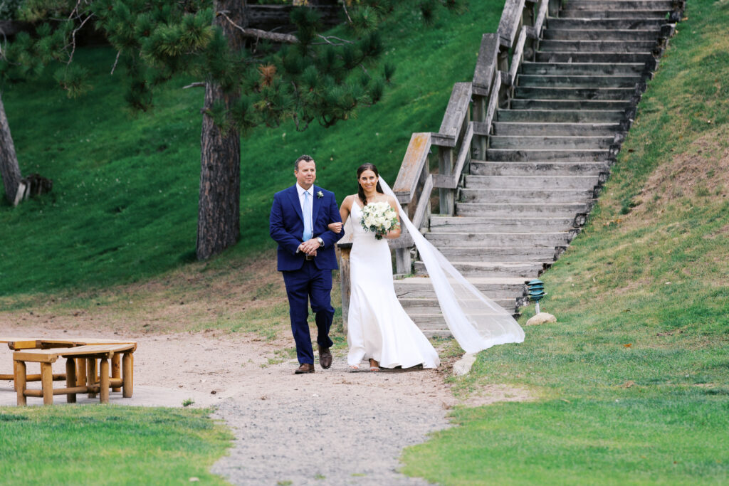 Bride walking down the stairs with her dad during the ceremony at Madden’s Resort on Gull Lake, captured by Minnesota wedding photographer.
