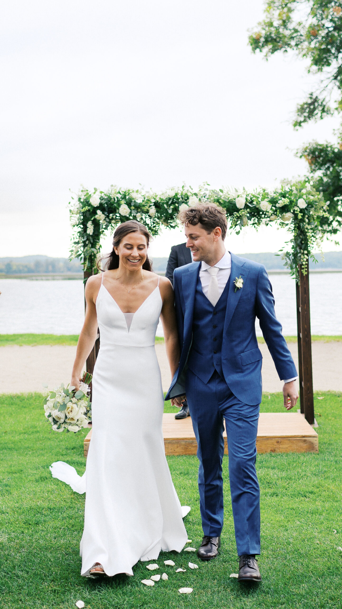 Bride and groom walking hand in hand, just married and celebrating their vows at Madden’s Resort on Gull Lake, captured by Minnesota wedding photographer.