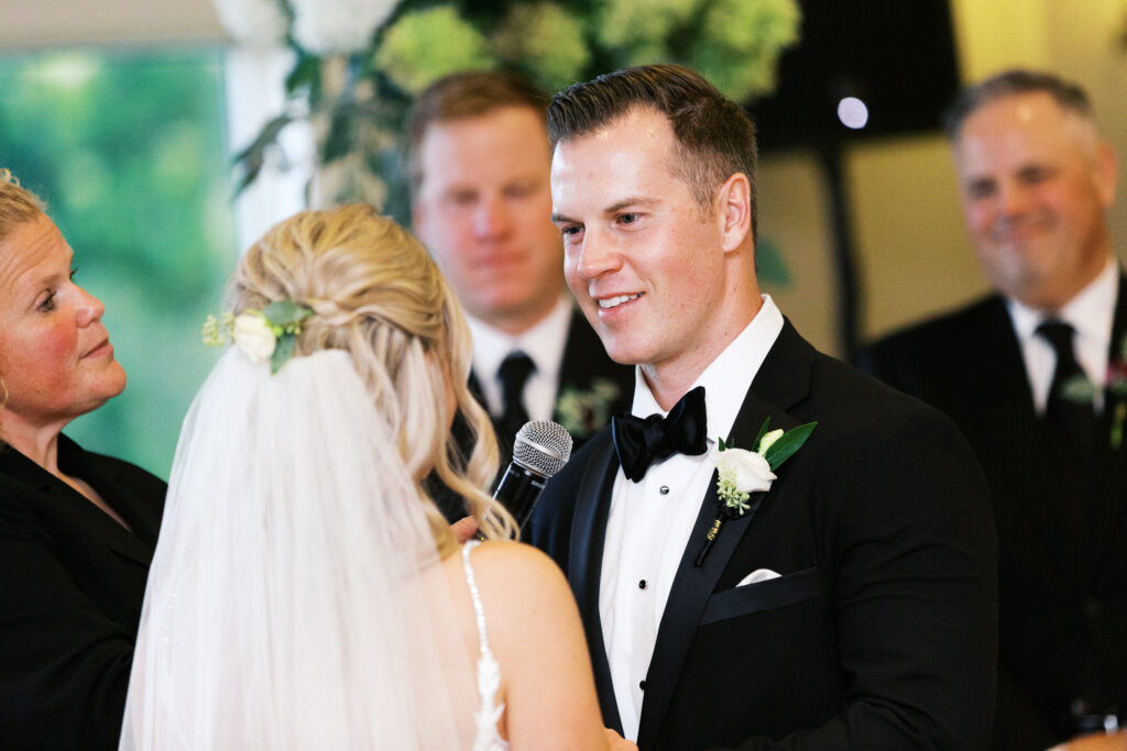 Bride and groom hold hands during their ceremony at Minneapolis Golf Club, captured by Minnesota wedding photographer Toly Dzyuba Photography.