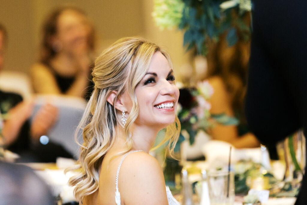 Bride laughing during heartfelt speeches.