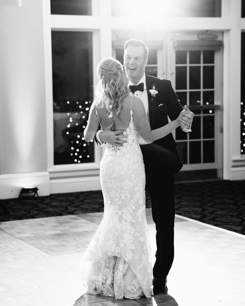 First dance under string lights, filled with love and laughter, documented by Minnesota wedding photographer.
