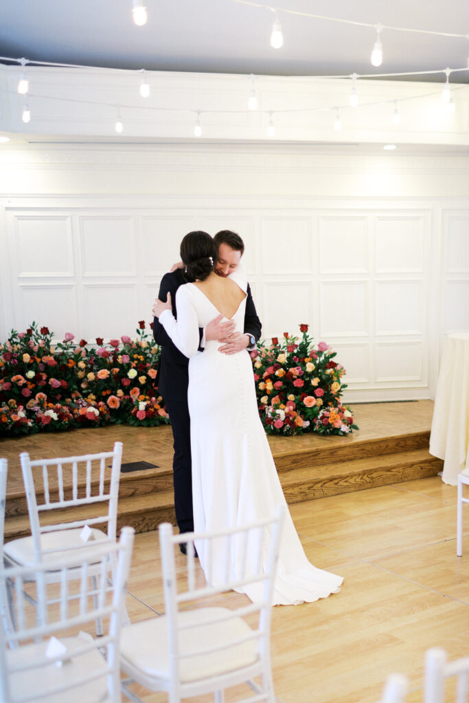 Groom hugs his bride at St. Paul College Club by Minnesota wedding photographer.