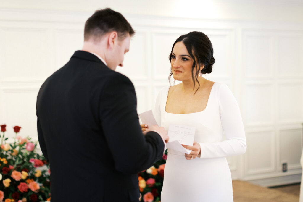 Bride and groom privately exchange wows with joy at St. Paul College Club by Minnesota wedding photographer.
