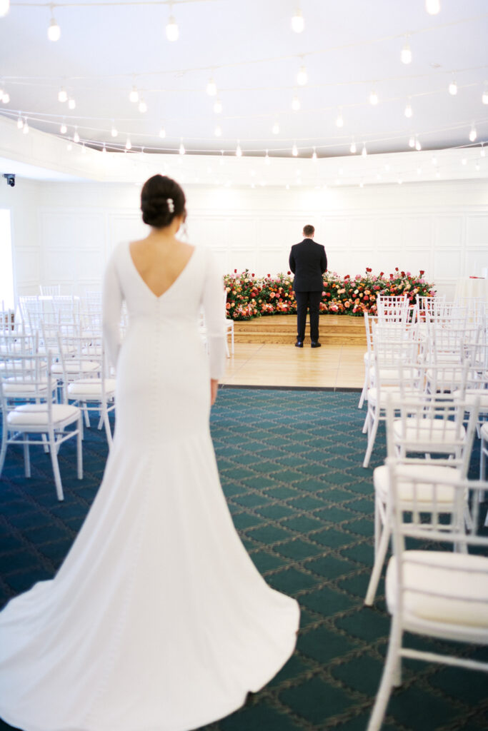 Bride and groom first look at St. Paul College Club surrounded by roses during an elegant winter wedding in Minnesota.