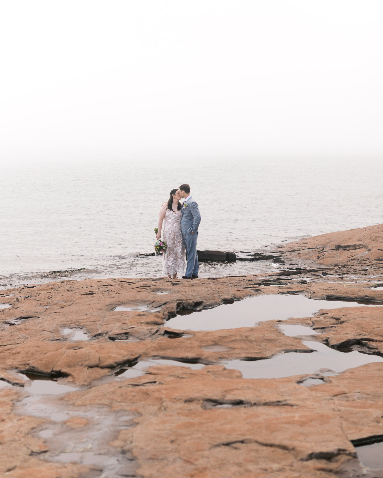 Bride and groom sharing a romantic kiss during their intimate Grand Marais wedding.